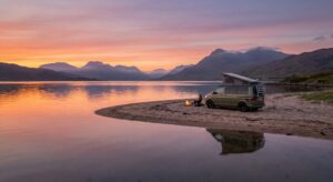Road trip en van en Écosse devant un château des Highlands au bord d’un loch